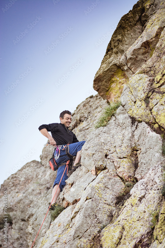 man climbing a rock wall