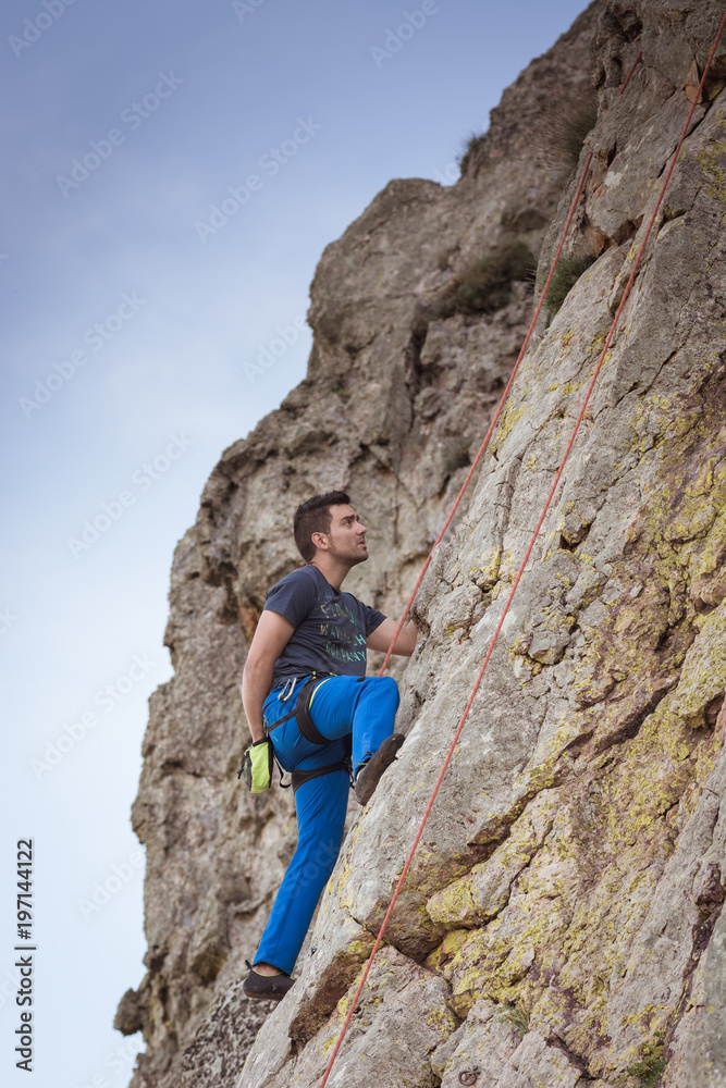 man climbing a rock wall