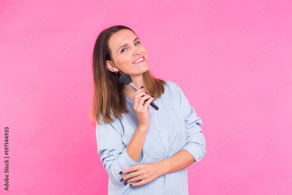 Professional makeup artist with brushes on pink background Professional makeup artist with brushes on pink background