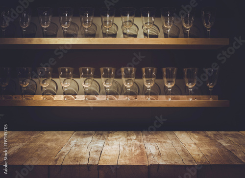 Empty the top of wooden table with blurred counter bar and glass Background