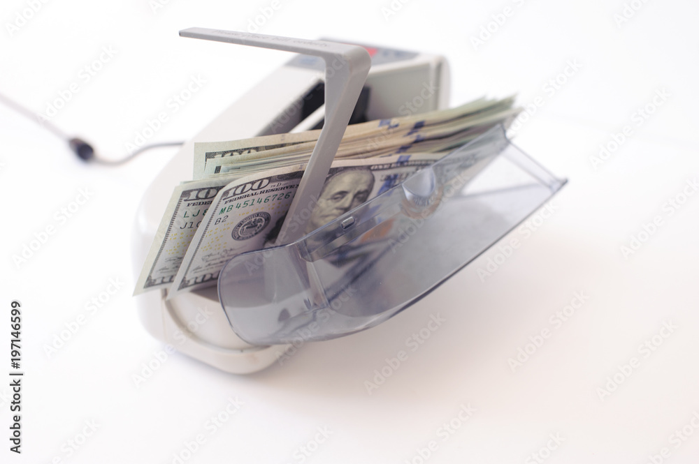 money counting machine on a white table. Banknotes are spread out money counting machine on a white table. Banknotes are spread out