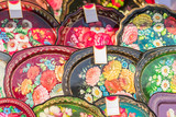 Colorful floral painted metal lacquer trays on display for sale at traditional fair