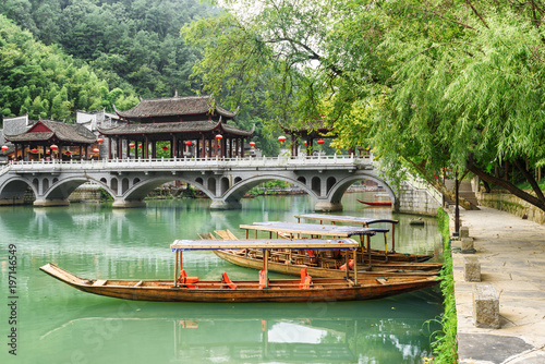 Parked wooden boats on the Tuojiang River, Fenghuang, China photo