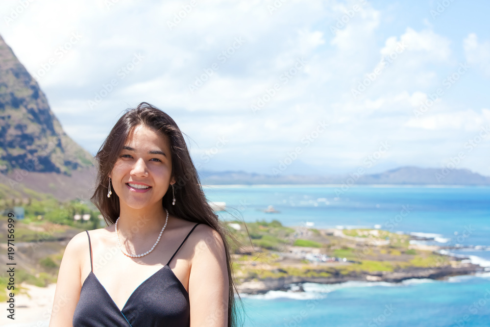 Happy teen girl smiling with Hawaiian ocean in background