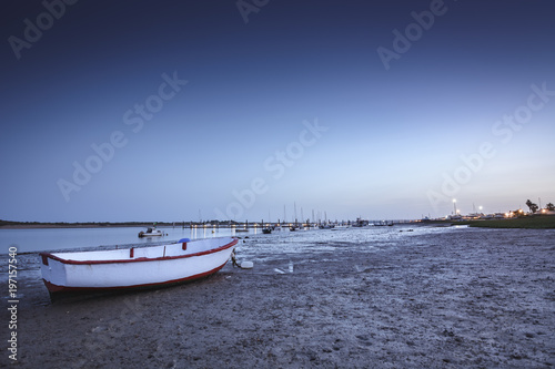 small boat on the shore of the sea at dusk
