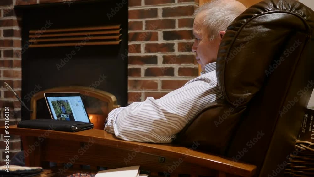 A dolly shot of a man using a computer in his home sofa A dolly shot of a man using a computer in his home sofa