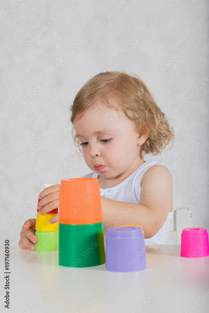 Small girl is building up a tower. Closeup Small girl is building up a tower. Closeup