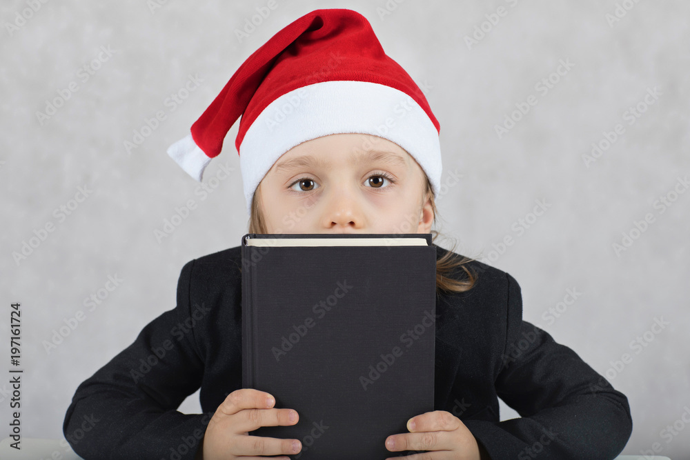 Boy in Santa's hat and black classical jacket. , Boy in Santa's hat and black book. Boy in Santa's hat and black classical jacket. , Boy in Santa's hat and black book.