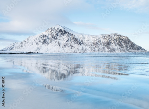 Mountain ridge and reflection on the seashore. Natural landscape in the Norway