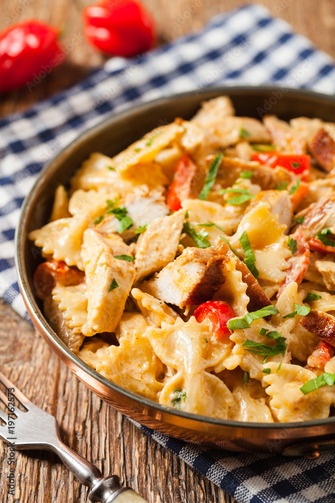 Pasta farfalle with chicken and paprika, in carbonara sauce.