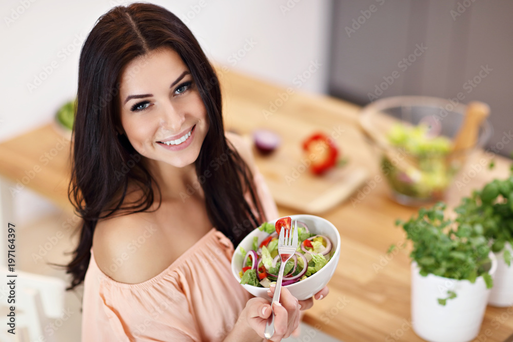 Happy woman preparing salad in modern kitchen Happy woman preparing salad in modern kitchen