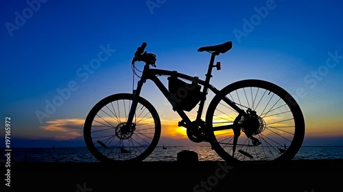 Wallpaper Mural Time lapse of sunset sky at sea with bicycle silhouette foreground, Zoom out shot Torontodigital.ca