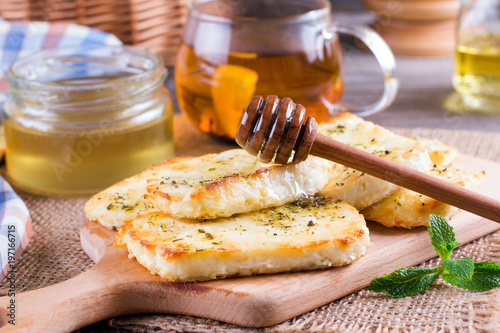 Grilled haloumi cheese with herbs on a cutting board photo