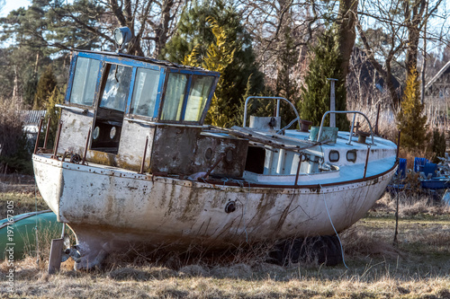 An old  broken and rusty fishing boat lies on land. Concept vacation and travel or maritime