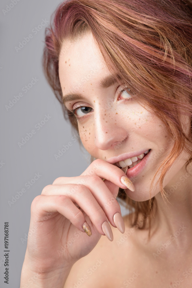 Woman a freckles on the face. Portrait of pretty beautiful female model with a perfect skin. Red hair with pink lock of hair Woman a freckles on the face. Portrait of pretty beautiful female model with a perfect skin. Red hair with pink lock of hair