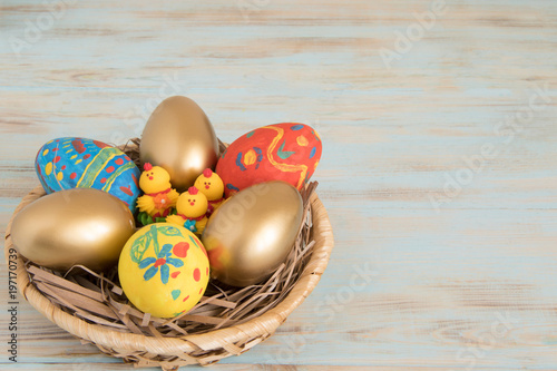 Color Easter eggs in a basket with yellow baby chicken Easter concept photo