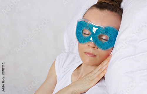 Young lady is keeping eye gel mask.
