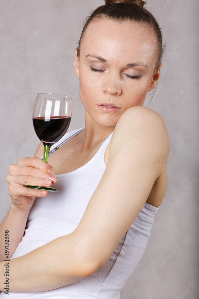 Young lady keeps a glass of red wine in her hand Young lady keeps a glass of red wine in her hand