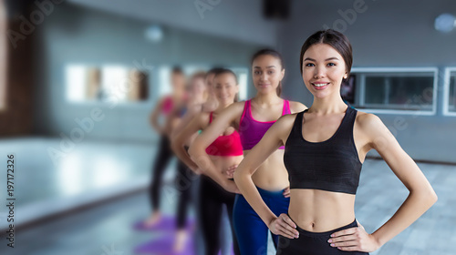 Good healthy sporty life. Six Multiracial beautiful ladies in trendy sports outfit  in a gym, standing in a row, so slim and happy. © My Ocean studio