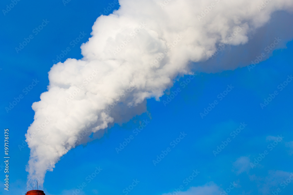 smoke from a pipe in the factory against a blue sky