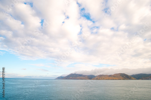 Landscape of the Mountain and sea with cloudy in the morning. View from the ferry to  South Island, New Zealand. © Klanarong Chitmung