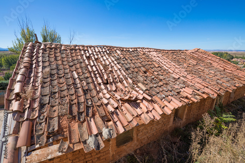 roof of building depressed with old clay tiles broken and blue sky   © Q