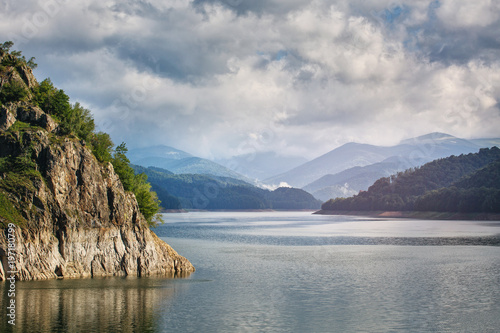 Panorama of a mountain lake Near the dam. Beautiful blue sky with clouds © serkucher