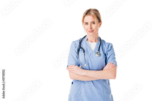 Female nurse in uniform with stethoscopes standing with arms folded isolated on white photo