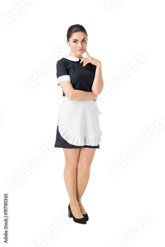 Brunette maid in professional uniform with hand by face isolated on white