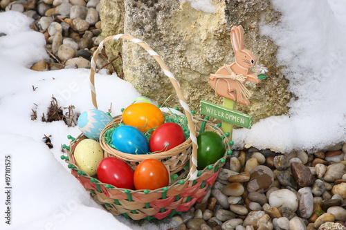 osterhase mit eiern im winterlichen steingarten