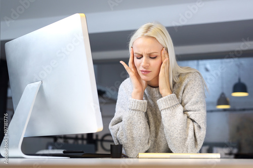 Migrenowy ból głowy. Zmęczona kobieta pracuje przy komputerze