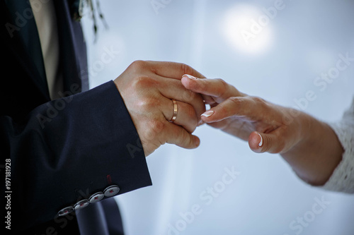 groom puts on an engagement ring to the bride