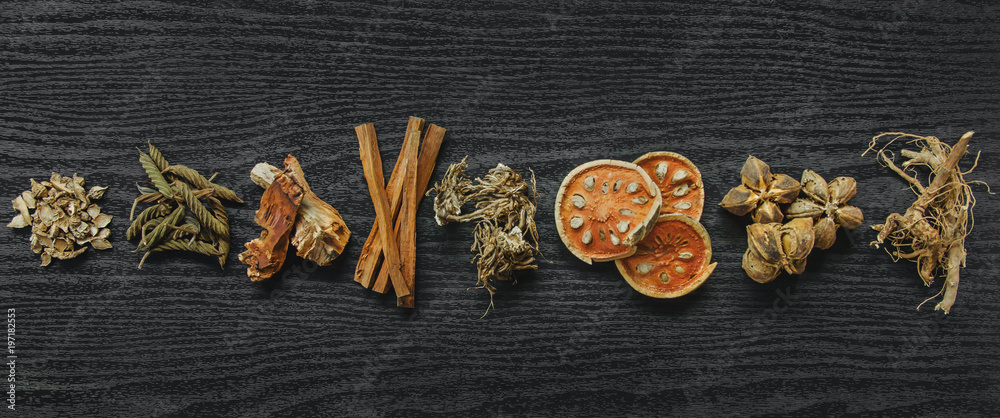 Dried herbs and Ginseng, Top view of Thai herbs and ginseng on wooden floor. Slices of dries root for make a herb juice on the dark table. Dried herbs and Ginseng, Top view of Thai herbs and ginseng on wooden floor. Slices of dries root for make a herb juice on the dark table.