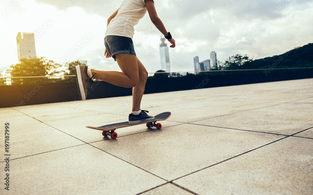 Woman practicing with skateboard at sunrise city