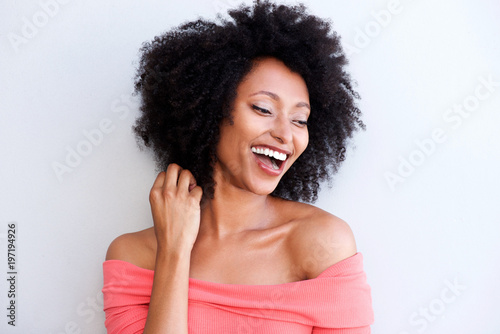 Close up attractive young black woman laughing against white background