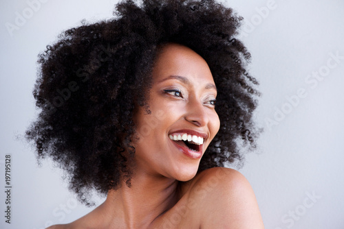 beautiful black woman with curly hair laughing and looking away