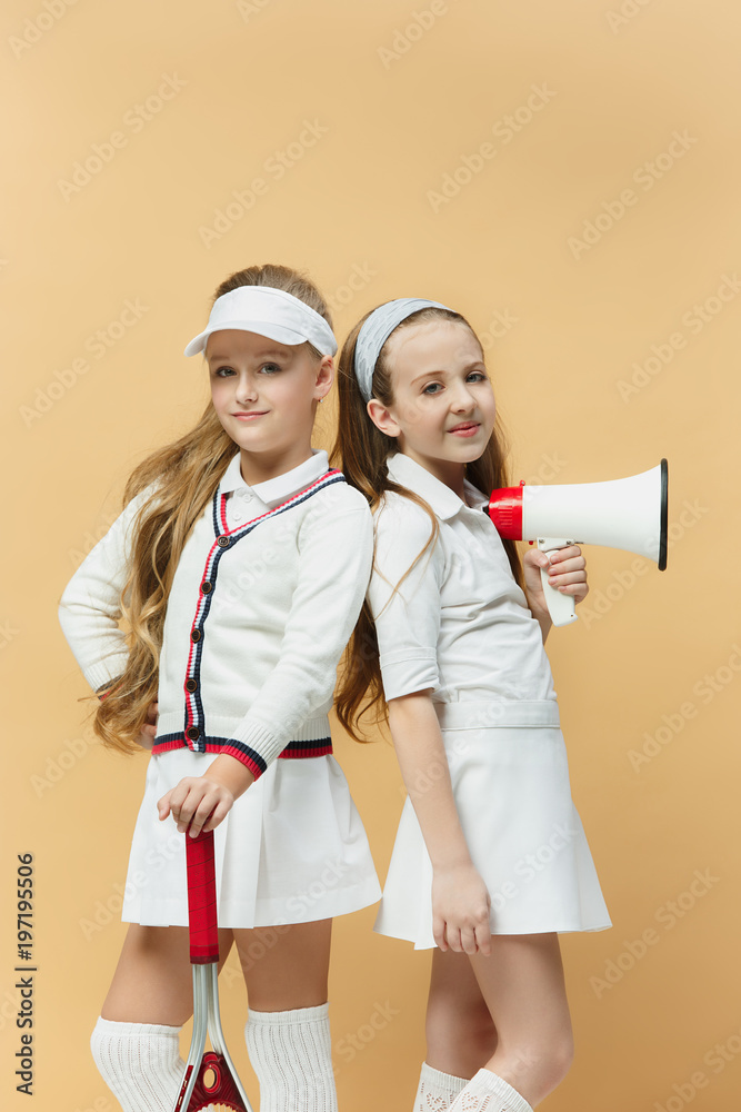 Portrait of two girls as tennis players holding tennis racket. Studio shot. Portrait of two girls as tennis players holding tennis racket. Studio shot.