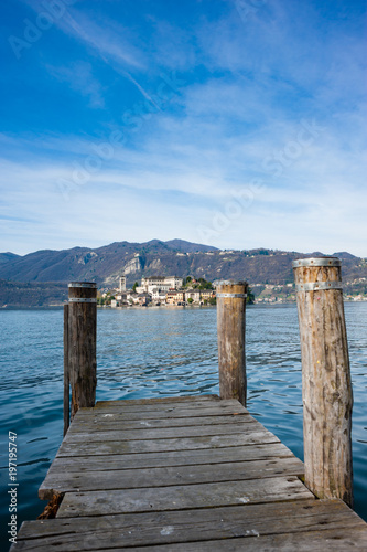 Wooden dock on Lake Orta  opposite the island of San Giulio island with a Benedictine nunnery monastery