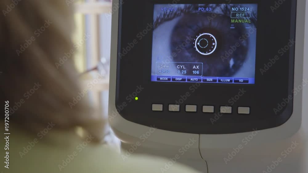 An optician looking at a big screen which is showing an eye An optician looking at a big screen which is showing an eye