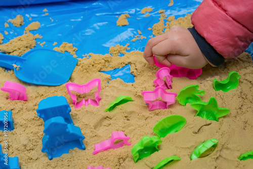 kid playing sand and plastic moulds