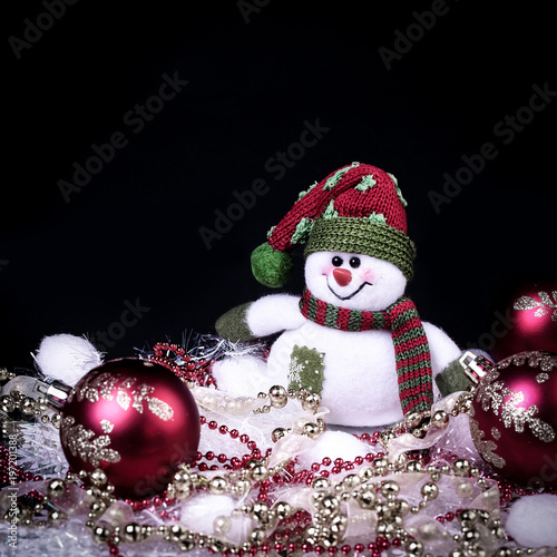 fun toy snowman and Christmas decorations on a black background