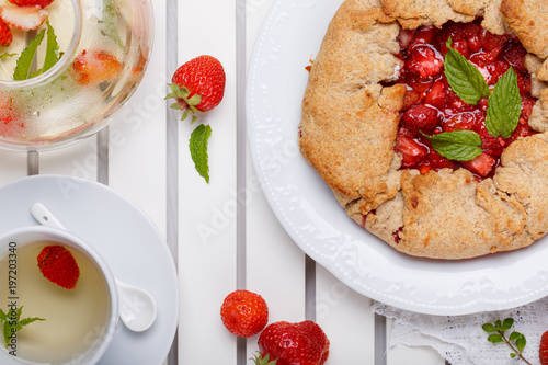 Strawberry galette and herb tea. Homemade healthy wholegrain berry open pie. Fruit tart. Top view.