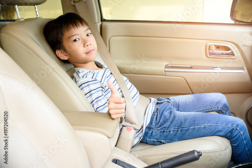 Young Asian boy fasten seat belt