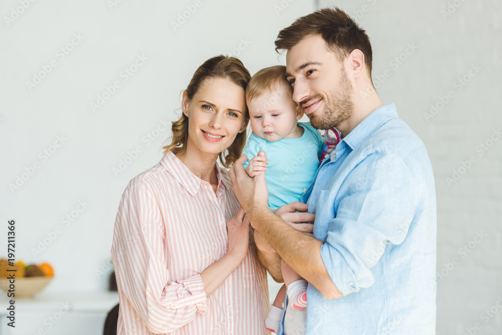 Young smiling family with infant daughter in hands Young smiling family with infant daughter in hands