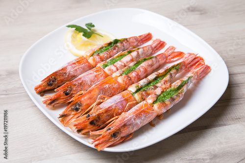 Baked langoustines on a white plate. Selective focus, close-up.