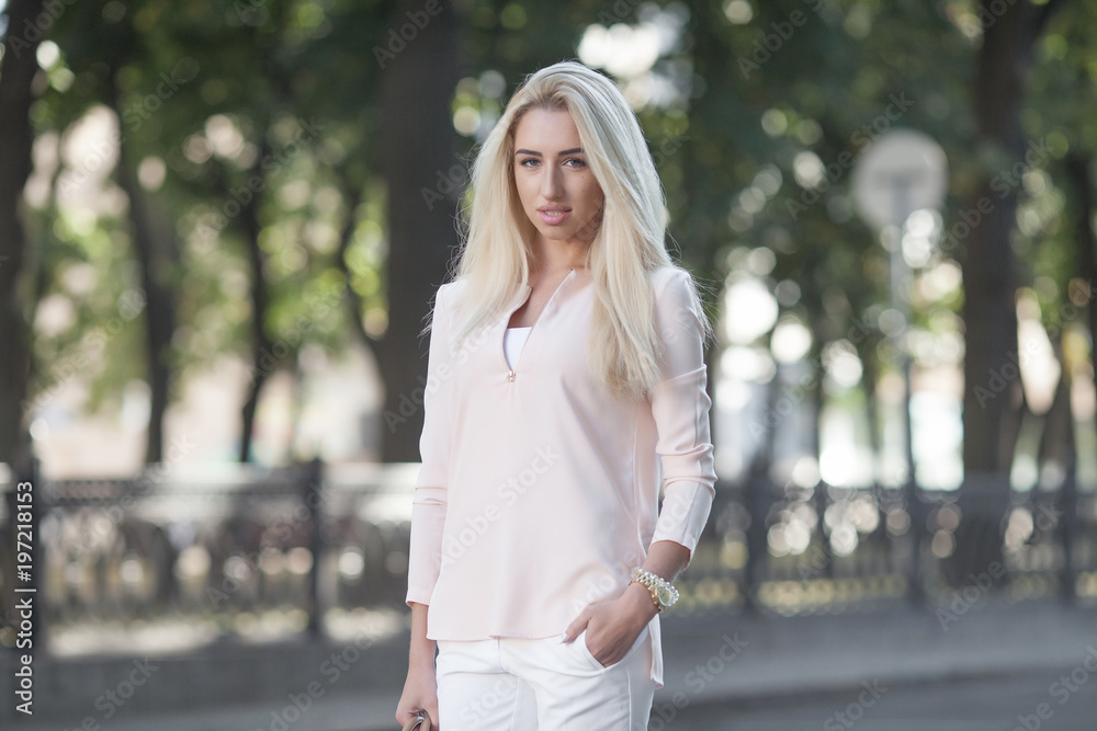 Beautiful business lady in the city. Professional make-up and blond hair. Summer shot. Beautiful business lady in the city. Professional make-up and blond hair. Summer shot.