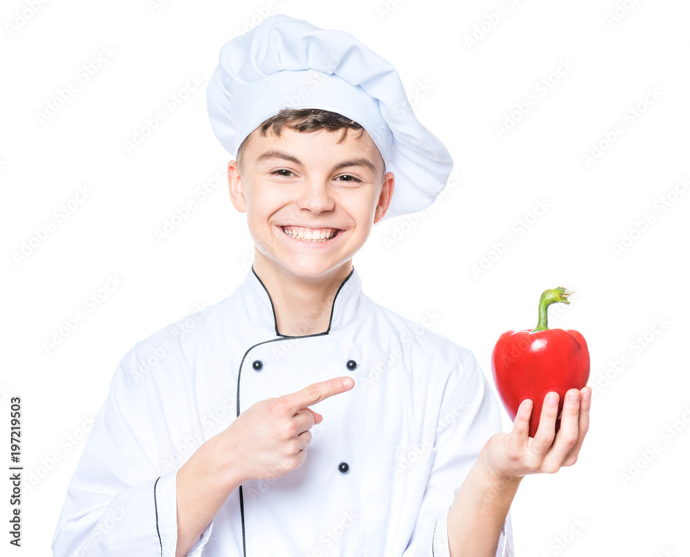 Handsome teen boy wearing chef uniform holding red pepper. Portrait of a happy cute male child cook, isolated on white background. Food and cooking concept. Handsome teen boy wearing chef uniform holding red pepper. Portrait of a happy cute male child cook, isolated on white background. Food and cooking concept.