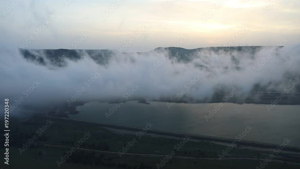Beautiful clouds flying over the lake near mountains. Evening time shot over the clouds. Baku, Azerbaijan Beautiful clouds flying over the lake near mountains. Evening time shot over the clouds. Baku, Azerbaijan