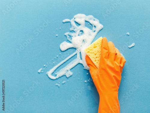Hand in glove washing glass surface with sponge and cleaning foam photo