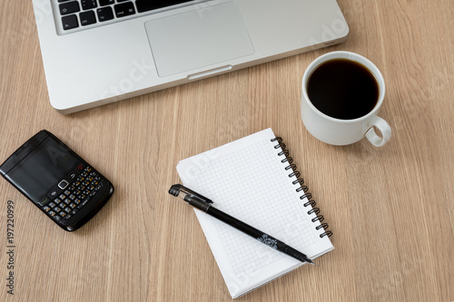 white notebook with pen on desk and phone